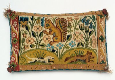 En stift kudde gobeläng panel med en ekorre och motto, "god vilja är allt" av English School