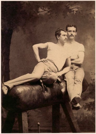 Porträtt av två gymnaster som poserar på en käpphäst, ca 1899 (svartvitt foto) av English School