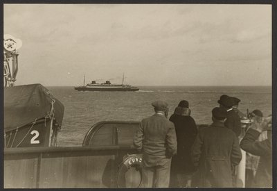 [Grupp av människor på ett fartygsdäck som ser ett annat fartyg segla förbi i fjärran] av Erich Salomon