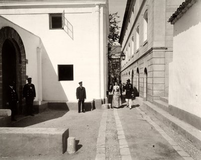 Män i uniform som följer med en elegant klädd kvinna mot kyrkan på gården Lo Zucco, Sicilien, 1900 av Eugenio Interguglielmi