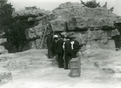 En grupp djurhållare som packar upp heliga babianer bland klipporna på "Monkey Hill", London Zoo av Frederick William Bond