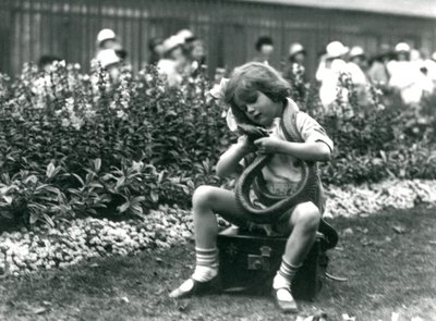 En ung flicka Betty som håller en östlig indigorm när hon sitter på en läderkoffert, London Zoo, 1924 av Frederick William Bond