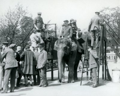 Besökare som köar för en elefantritt medan andra går ombord, med hjälp av fem djurhållare, London Zoo, 1927 av Frederick William Bond
