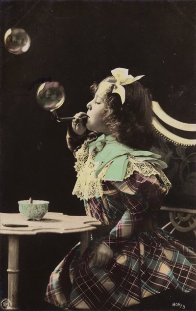 En liten flicka som blåser bubblor från ett rör (tonat foto) av French Photographer