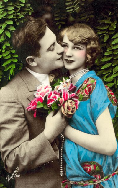 Man som bär blommor och kysser en vacker flicka på kinden av French Photographer