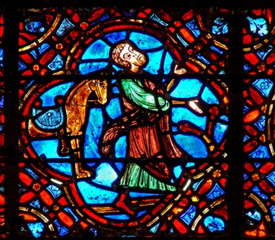 Fönster w12 som visar en scen i det barmhärtige samaritfönstret: samariten kliver av sin häst av French School