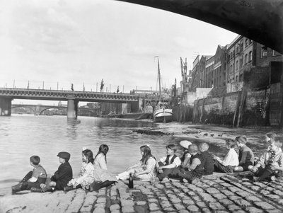 Barn på den kullerstensbelagda vägbanan under Southwark Bridge, London, c1930 av George Davison Reid