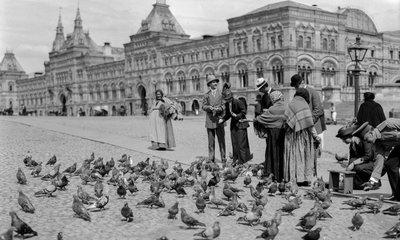 Matning av duvor på Röda torget med de övre handelsraderna i bakgrunden. De övre handelsraderna... av Gilbert H. Grosvenor