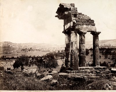 Vy över de återstående fyra kolumnerna som stöder en entablatur av Castor- och Polluxtemplet i Valle dei Templi, Agrigento. Ett panorama över staden syns i bakgrunden av Giorgio Sommer