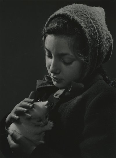 Flicka håller en vit kattunge i famnen. Tidigt 1950-tal av Godfrey Macdominic