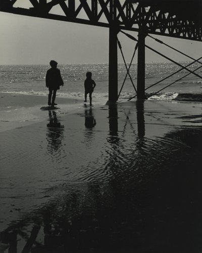 Två barn leker på stranden. av Godfrey Macdominic