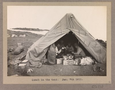 Fyra expeditionsmedlemmar äter lunch i ett tält av Herbert Ponting