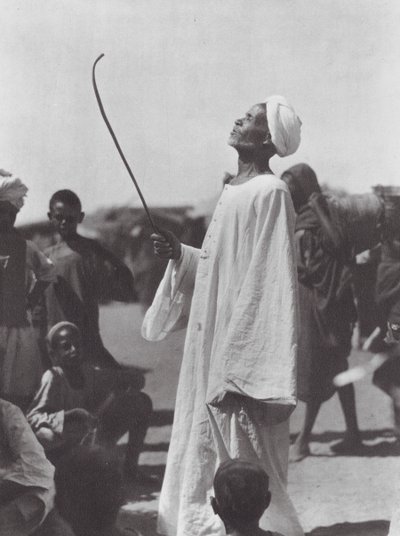 Afrika: Gammal man hånar dansare (svartvitt foto) av Hugo Adolf Bernatzik