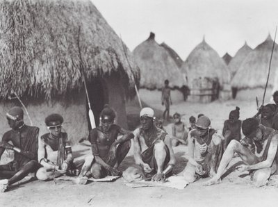 Afrika: Shilluk-krigare gnider in sig med träaska (svartvitt foto) av Hugo Adolf Bernatzik
