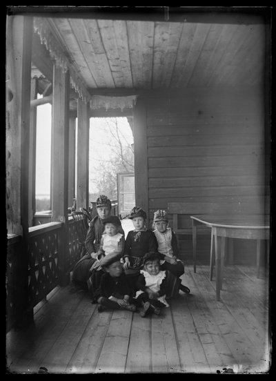 Elma Simberg och andra släktingar på verandan till Gula Villan av Hugo Simberg