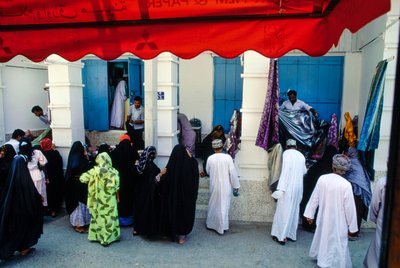 Marknad utomhus i Muscat, Oman handlare visar upp textilier av James L Stanfield