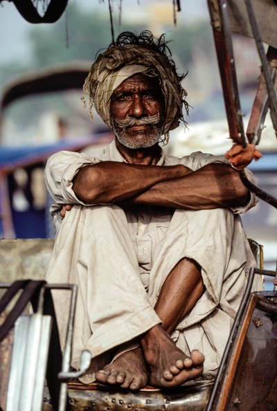 Pakistansk rickshaw-taxichaufför väntar på en biljett i Karachi, Pakistan av James L Stanfield