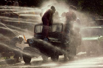 Människor besprutas vid vattenfestivalen under det buddhistiska nyåret. Mandalay, Burma. av James L Stanfield