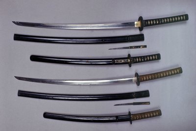 Överst: en katana, japanskt svärd och dess slida, wakizashi, japanskt kort svärd i dess slida, liten Kokatawa dolk stuvar i samma skida. alla tre är från 1700-talet. de lägre är från 1600-talet. av Japanese School