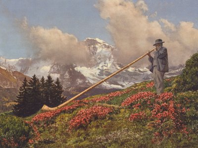 Schweiz: An Alphorn Blower, Jungfrau i bakgrunden (färgfoto) av Jean Gaberell