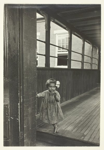 Liten flicka står vid ingången till ett galleri av Lewis Wickes Hine