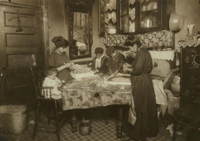 Mrs Mette och hennes barn (Josephine 13, Nicholas 6 och Johnnie 8 som tillsammans tjänar endast 40-50 cent per dag) gör blommor i en smutsig hyresrätt i New York, 1911. av Lewis Wickes Hine