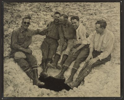 [Gruppporträtt av personer sittande vid mynningen till en vertikal grotta, San Jacinto Peak] av Louis Fleckenstein