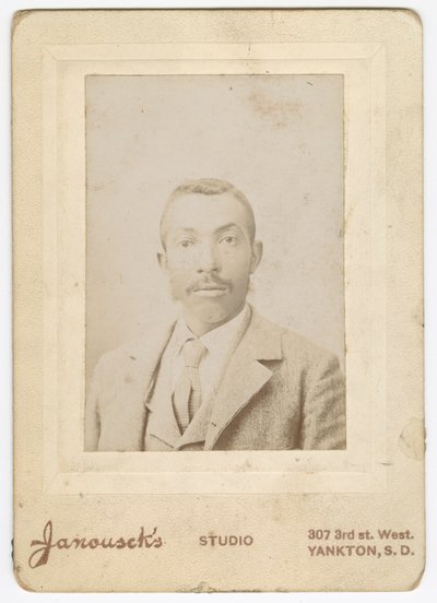 Fotografi av en man klädd i en ljus jacka, väst och slips, sent 1800-tal. av Louis Janousek