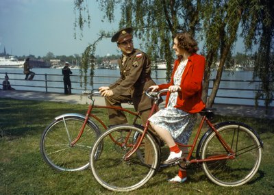 En amerikansk arméofficer sitter på en cykel nära en hamn och flirtar med en ung kvinna på Trini... av Luis Marden