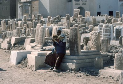 Jemenitisk man reciterar Koranen på kyrkogård med gravar i Sayun, Hadramawt, Sydjemen. av Lynn Abercrombie