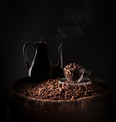 Mörk kaffekanna och kaffebönor av Margareth Perfoncio
