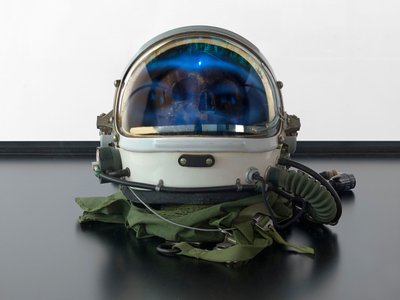 Alpha Omega, 2016 (Glas, LCD-skärm, mediaspelare, replikaskalle, rymdhjälm, trä) av Mat Collishaw
