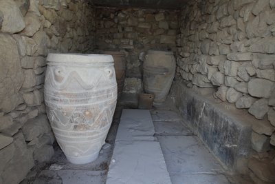 Minoiska arkeologiska platsen Phaistos. Magasinet för den gigantiska pithoi (förvaringsburkar). Dessa burkar är dekorerade med skiv- och repmönster i relief. av Minoan