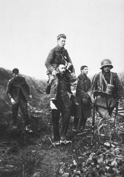 En tysk infanterisoldat med ett skadat ben bärs från strid av engelska krigsfångar (s/v foto) av Photographer German