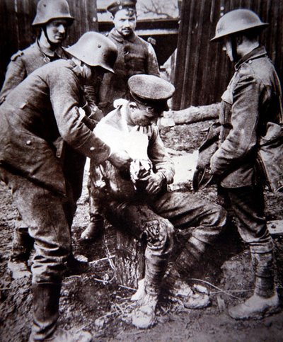 Första världskriget tysk läkarvårdare som vårdar en sårad brittisk soldat på västfronten av Photographer German
