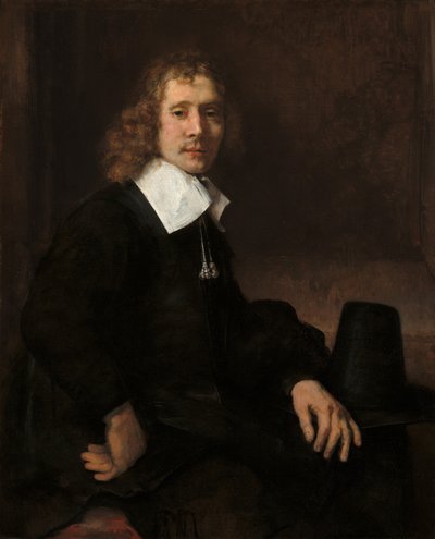 En ung man som sitter vid ett bord (möjligen Govaert Flinck) av Rembrandt van Rijn