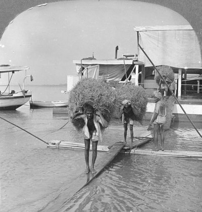Lossar ett fartyg på Irrawaddy River, Burma, 1908 av Stereo Travel Co