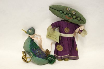Miss Green Peas trasdocka, huvudet är i form av en ärtskida och hon leder sin anka med ett rosa satinband av Una Maw