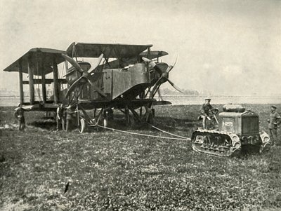 En liten motortraktor som får en enorm R.A.F. Bombmaskin i position..., 1919. av Unbekannt