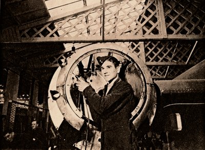 En metallarbetare med automatisk borr som strippar ett motorhölje, 1940 av Unbekannt
