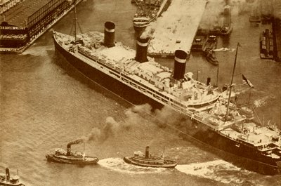 Ett flygfoto av Leviathan som bogseras av små bogserbåtar i hennes brygga i New York, c1930 av Unbekannt