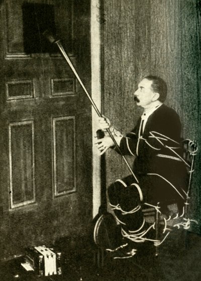 John Nevil Maskelyne utför en andekabinettillusion, c1910. av Unbekannt