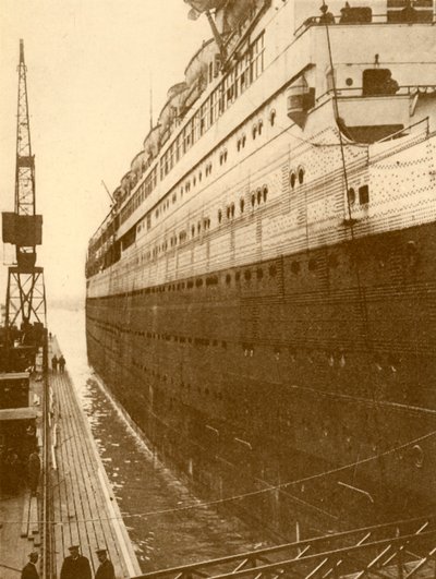 Vy över styrbords sida av majestätiska när hon gick in i den flytande torrdockan, c1930. av Unbekannt