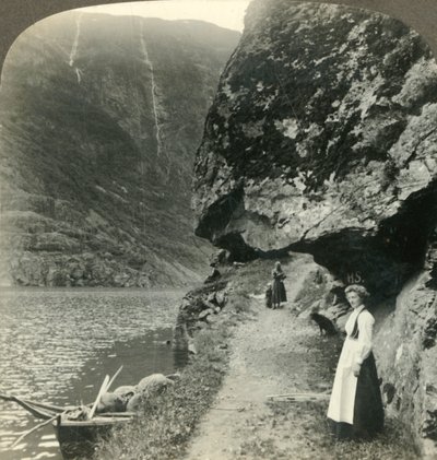 Där vägen kryper under de utskjutande klipporna vid vattnet i Nerofjorden, Norge, c1905. av Unbekannt