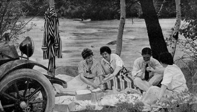 Nordamerika. Picknickfest attackerar lunchkorgen under en motorresa till Ozark-bergen. 1920 av Unbekannt