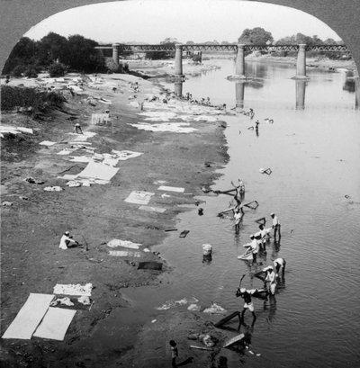 Dobbies tvättar kläder i Gomti River, nära Lucknow, Indien, 1900-talet. av Underwood and Underwood