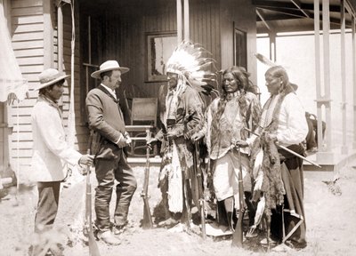 Tre cheyenner klädda i ceremoniell kostym och bärande vapen hälsar på en vit tillsammans med en tolk. sd. sent 1800-tal av Unknown artist