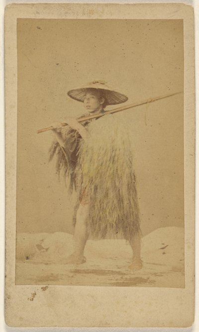 [Japansk man iförd regncape och hatt av halm, bär på en lång påle] av Unknown artist