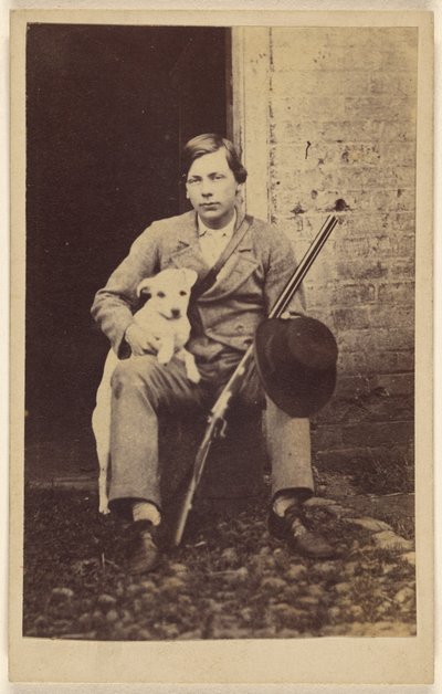 [Sittande man med vit hund, gevär och hatt lutad på benet] av Unknown artist