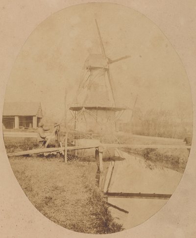 [Målare i hatt vid staffli som målar en väderkvarn] av Unknown artist